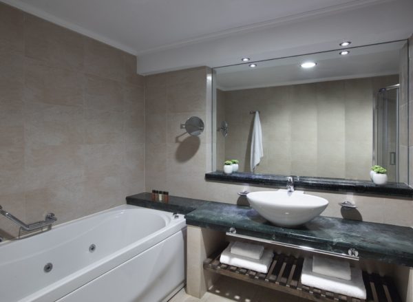 Bathroom with bath tub and sink at Apollo Blue Hotel