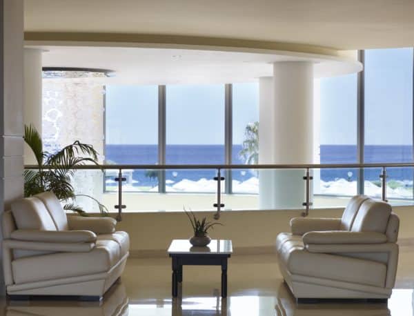 Armchairs and table in the upper level of the lobby at Apollo Blue Hotel