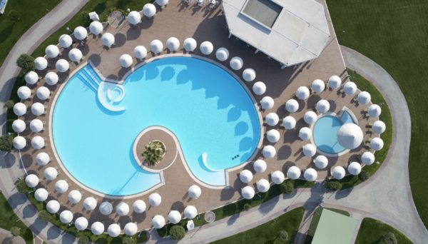 The circular main pool at Apollo Blue Hotel surrounded by sun umbrellas