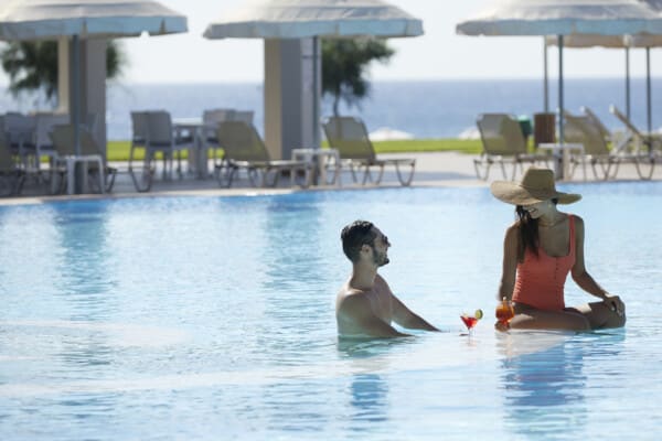 Rhodes luxury hotel with pool with couple enjoying a cocktail