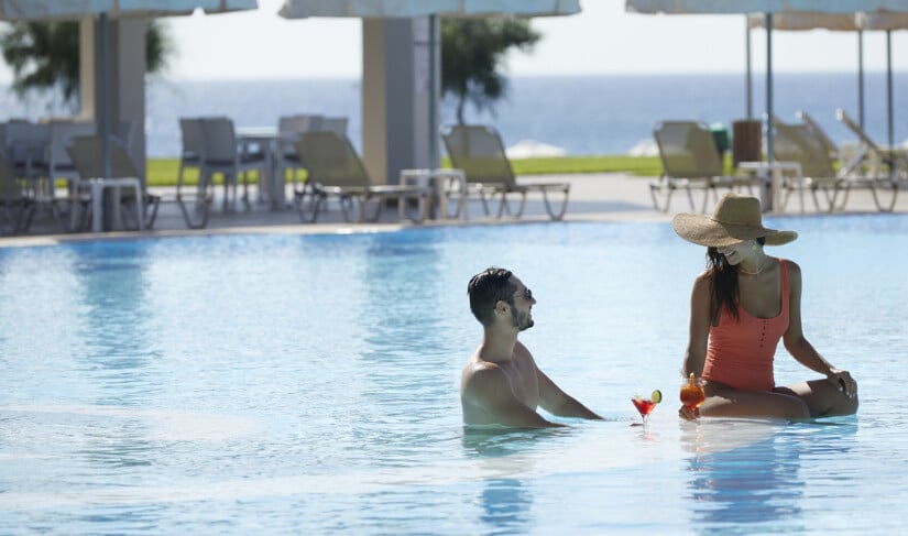 Rhodes luxury hotel with pool with couple enjoying a cocktail