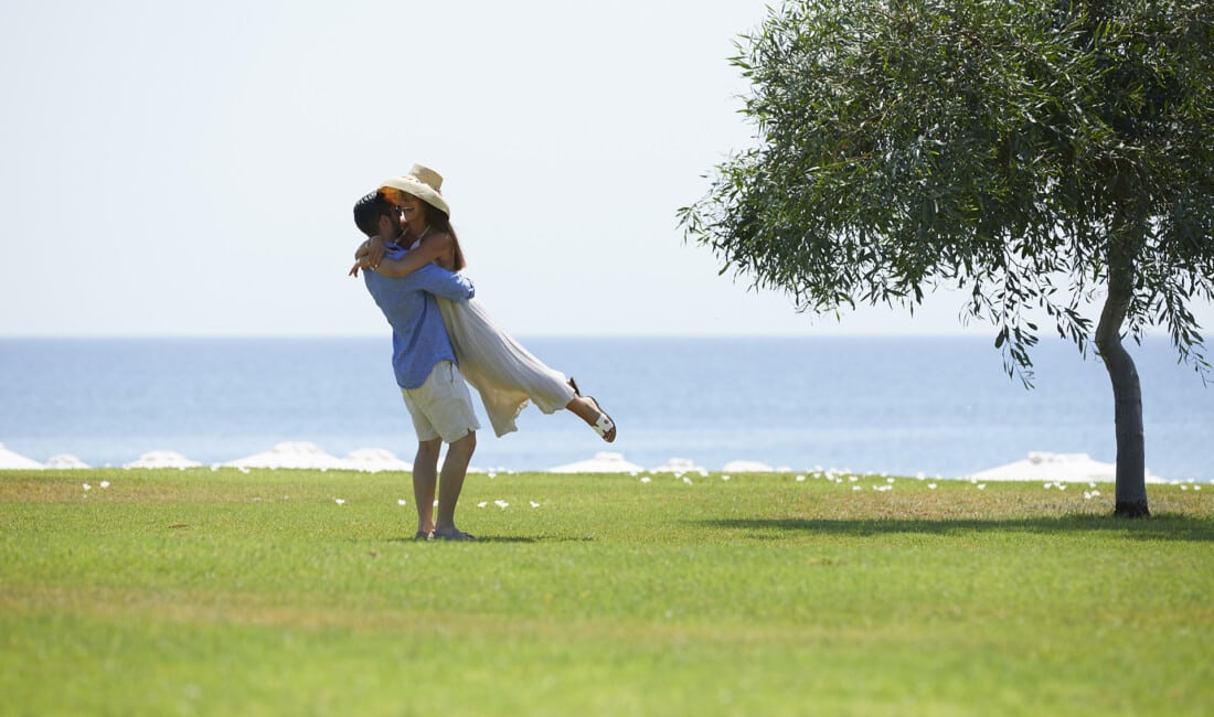 Happy couple sharing a warm embrace at the lawn of Apollo Blue Hotel