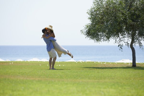 Happy couple sharing a warm embrace at the lawn of Apollo Blue Hotel